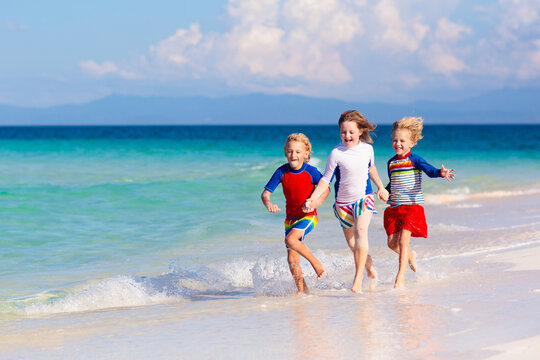 Kids Playing On Beach. Children Play At Sea.