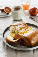 Breakfast with Twisted Bun with cheese and jam, hot chocolate, juice and oranges. Red-Jam and Cheese Danish. Selective focus