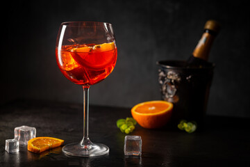 Aperol spritz cocktail in glass with fresh orange on dark background