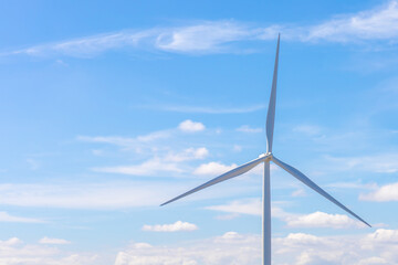 Electric wind turbine with blue sky and clouds.