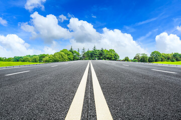 Asphalt road and green trees in spring season.