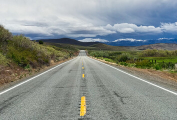 Naklejka premium Lonely asphalt road through the mountains in Nevada, USA