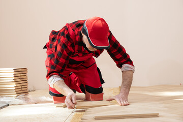 Worker installing parquet floor during home renovation, Construction in a renovated room installation of parquet