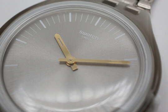 Geneve, Switzerland 07.10.2020 - Swatch swiss logo on gray wristwatch dial of swiss made mechanical watch close up. Time is ticking concept. Swatch Group watch production