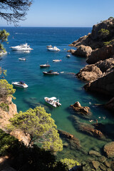 Rocky cove with boats in Costa Brava, Tossa de Mar, Spain