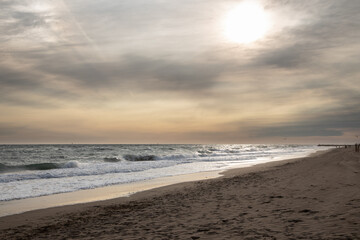 Foggy beach with the sun through the clouds in Gava, Spain