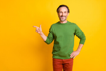 Photo of funny bearded guy direct finger empty space wear green pullover isolated vivid yellow color background