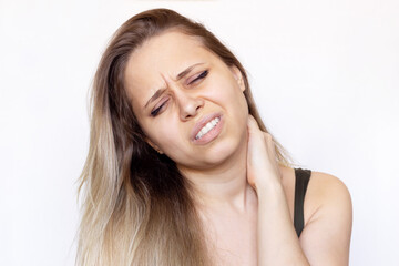 Fototapeta premium A young beautiful caucasian blonde woman with a neck pain holding her neck isolated on white background. The girl suffers from an osteochondrosis