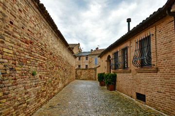 A narrow street between the old houses of Montecosaro, a medieval town in the Marche region of Italy.