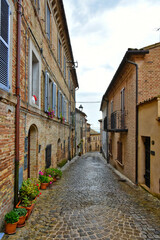 A narrow street between the old houses of Montecosaro, a medieval town in the Marche region of Italy.