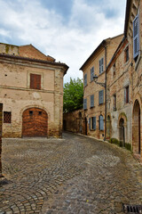A narrow street between the old houses of Montecosaro, a medieval town in the Marche region of Italy.