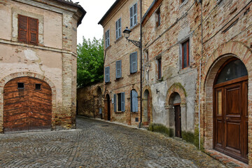 Fototapeta na wymiar A narrow street between the old houses of Montecosaro, a medieval town in the Marche region of Italy.
