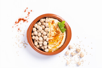 Bowl of homemade hummus isolated on white background. Top view, flat lay  with copyspace.