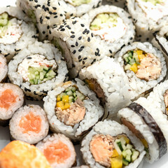 Sushi tuna rolls decorated with sesame seeds and masago or tobiko caviar. Inside-out Sushi Set. Different types of sushi rolls. Asian or Japanese food, Oriental cuisine. Close up shot. Top view.