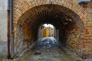 A narrow street between the old houses of Montecosaro, a medieval town in the Marche region of Italy.