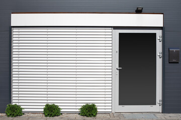 Window and door closed with shutters on the gray wall.