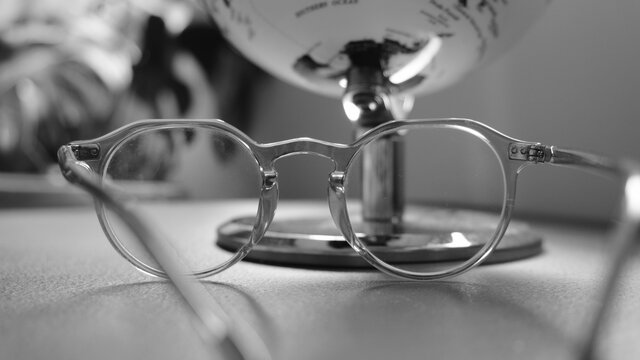 Eyeglasses and globe on table