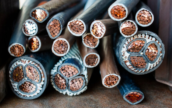 Macro photo of many copper wires twisted into rods and covered with plastic or gum isolation. Isolated copper wire endings cutted in half lying on a pile.