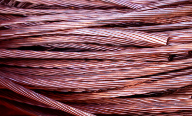 Orange and pink copper wires twisted and mixed chaotic on a pile. Abstract texture of copper colored cables and filaments. 
