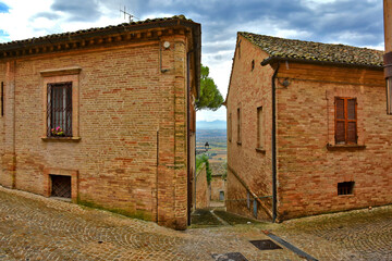 A narrow street between the old houses of Montecosaro, a medieval town in the Marche region of Italy.