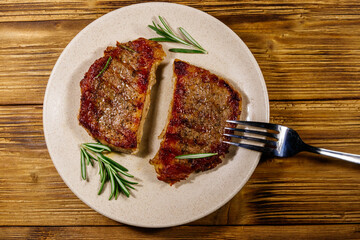 Grilled pork steaks with rosemary on wooden table. Top view