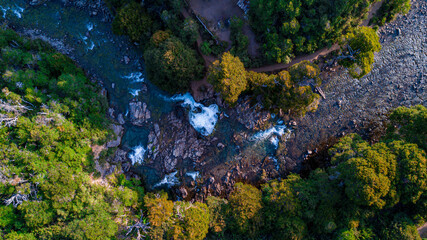 vista cenital de un rio del sur argentina, abriéndose camino entre las montañas y el bosque con sus aguas transparentes y cristalinas producto de deshielo de montañas
