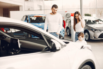 Family with little son in a car salon