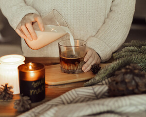 woman pours milk into coffee