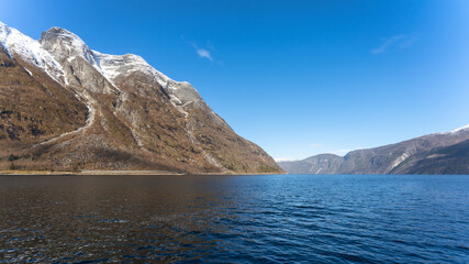 Fototapeta na wymiar Eidfjord, a Norwegian town and municipality in the Hordaland region, view from the beach on the Eidfjorden, the inner branch of the large Hardangerfjorden in Scandinavia