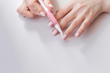 Female hands with pastel trendy manicure moisturizing cuticle.