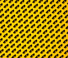 Black sunglasses pattern on yellow background. Summer concept