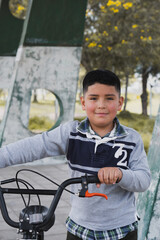 Boy walking with his bicycle.