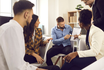 Collaborative process, briefing, project discussion. Male entrepreneur executive manager explaining business plan to boss and multicultural diverse skilled team during brainstorming meeting in office