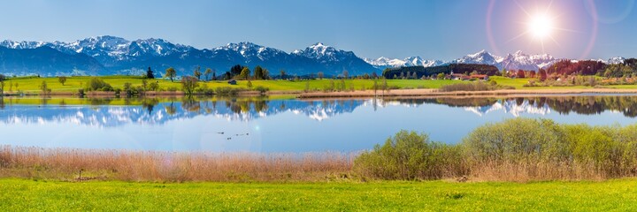 beautiful rural landscape in Bavaria with mountain range and meadow at springtime