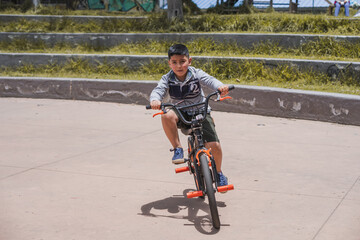 Boy walking with his bicycle.