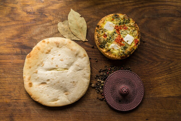 Broccoli quiche and salad leaves on wooden chopping board. Cheese and Broccoli Frittata