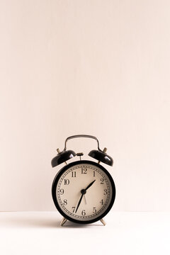 Retro alarm clock on wooden table Against White Background