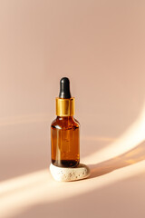 Essential oil or serum in glass bottle, hard light, deep shadows, copy space. Skin care concept - Image