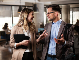 Colleagues in office. Businesswoman and businessman discussing work in office.
