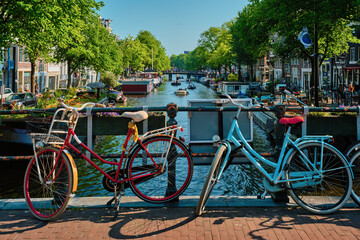 Fototapeta premium Amsterdam canal with boats and bicycles on a bridge