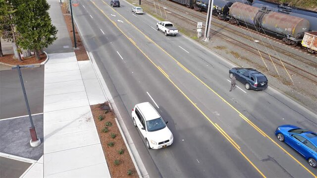 Man crosses a busy street narrowly avoiding being struck multiple times; illegal jaywalking theme
