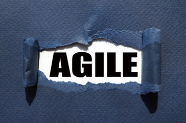 agile. text on white paper over torn paper background.