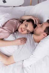 Obraz na płótnie Canvas Adult woman lying on chest of husband on bed