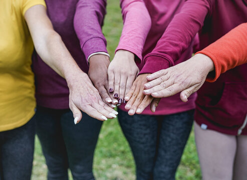 Stacking hands of multiracial women - Multi generational people - Team and unity concept