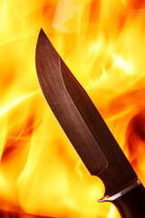 Damascus steel knife on the fire background.