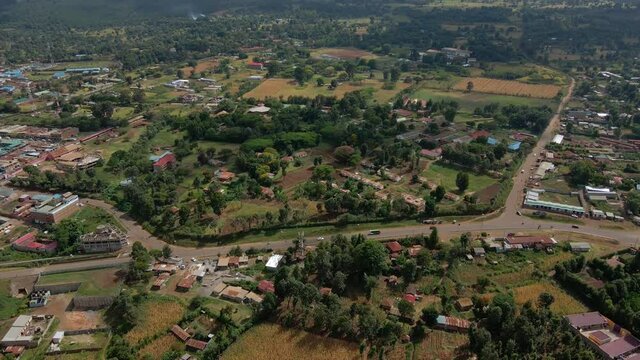 Aerial view over a town, revealing a forest fire and mountains - tilt, drone shot