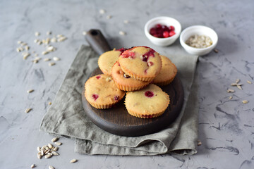 Vegetarian cupcakes with cranberries on a wooden board on a gray background