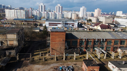 Abandoned industrial area. Old brick buildings and factory chimneys. Around a new residential city block. Aerial photography.