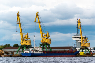 Fototapeta na wymiar Coal industry. Yellow working coal cranes in the industrial port.