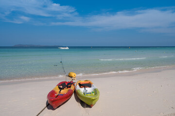couple of colorful kayak boats on white sand beach blue sea and clear sky with clouds, relax seascape view at Thian beach, Koh Larn island, Chonburi, Thailand